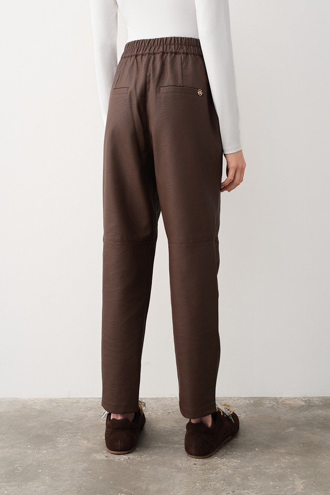 Pantaloni cu pliuri și aspect de piele