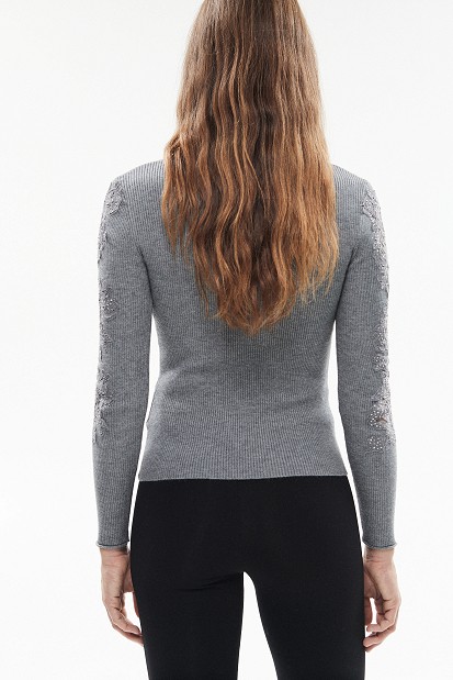 Knitted blouse with rhinestones and lace sleeves