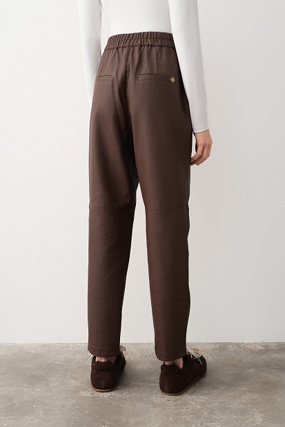 Pantaloni cu pliuri și aspect de piele