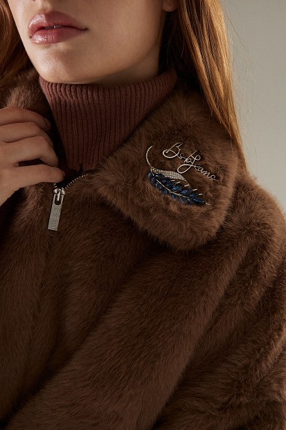 Cropped bomber jacket with decorative pins on the collar
