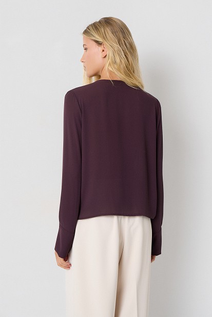 Wrap blouse with a decorative necklace