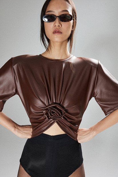 Cropped faux leather blouse with decorative flower