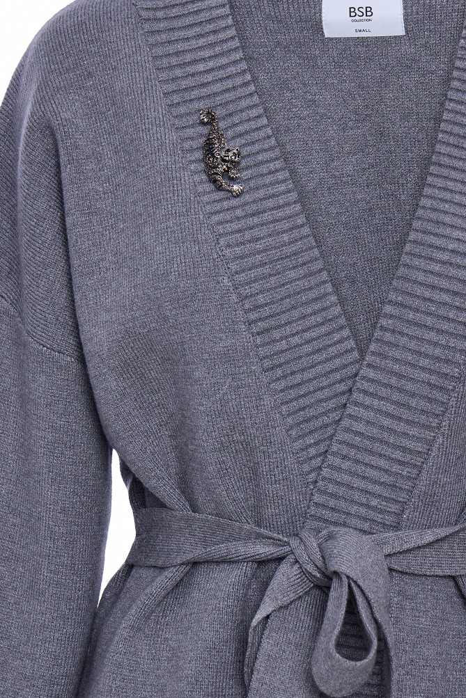 Cardigan with a belt and brooch.