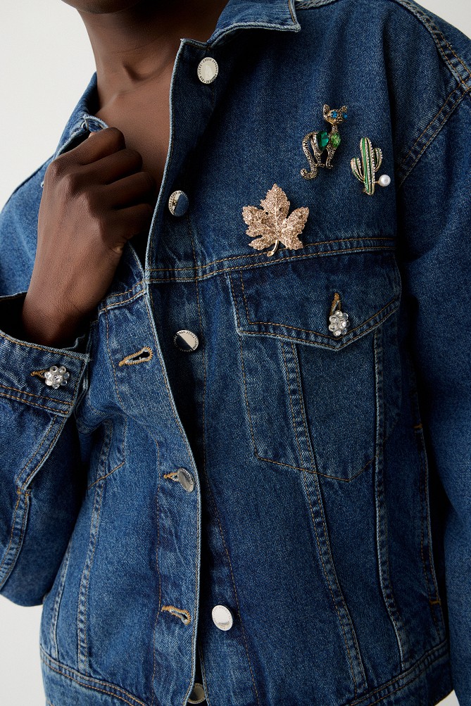 Denim jacket with decorative pins