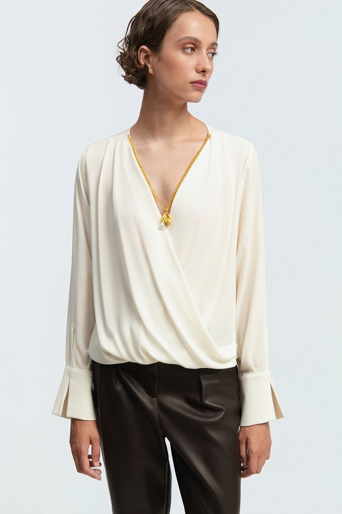 Wrap blouse with a decorative necklace