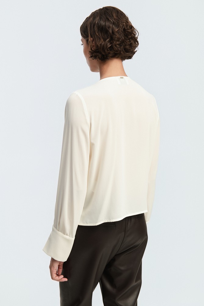 Wrap blouse with a decorative necklace
